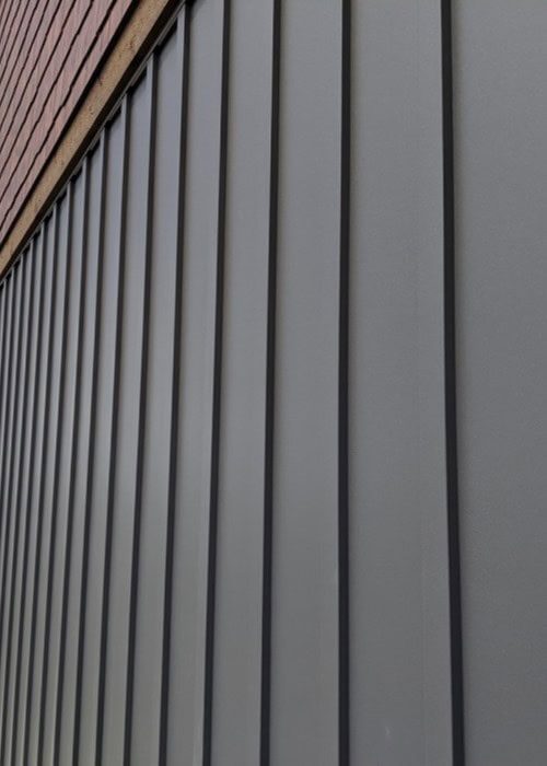 Various custom modules of Zeno-Clad™ cladding displayed in different materials including Zincalume® and Copper